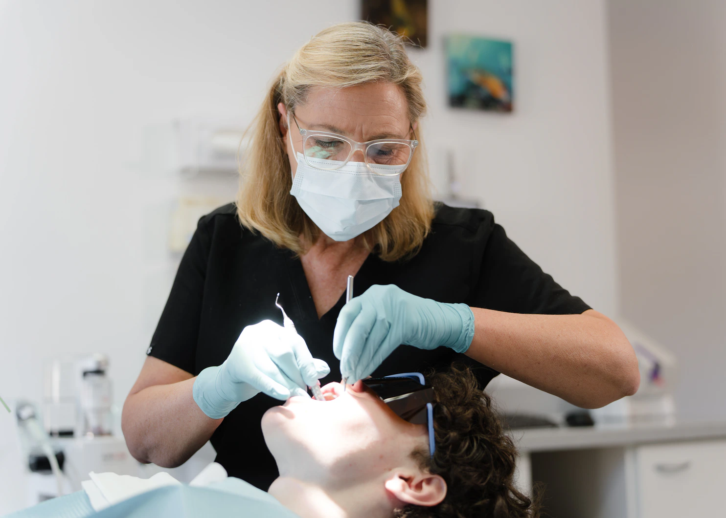 Dalkeith Dental clinician treating a reclined patient in the dental chair